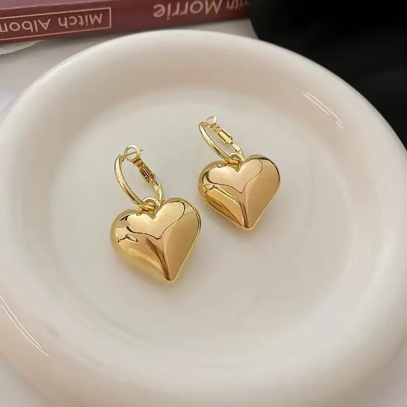 The sophisticated code of a hoodie, jeans, and heart-shaped earrings